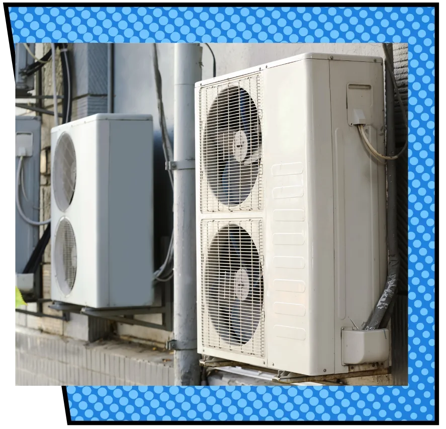 Two outdoor air conditioning units mounted on a building wall. The units are large, white, and rectangular, with visible fans behind mesh covers. Blue polka dot border frames the image.